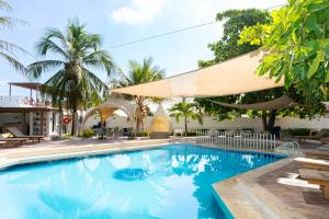 a swimming pool in a resort with palm trees at Hotel Tropical Inn in Tierra Bomba