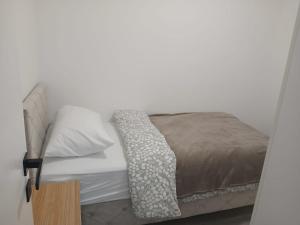a bed with a brown blanket on top of it at Apartman Herceg in Ljubuški +7 photos