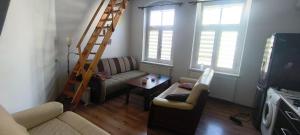 a living room with a ladder and a couch at Essa apartament in Brzeg