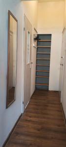 a hallway with a door and a mirror on the wall at Essa apartament in Brzeg