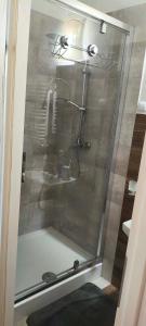 a shower with a glass door in a bathroom at Essa apartament in Brzeg