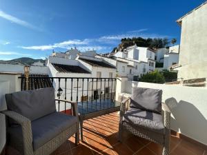 a balcony with two chairs and a view of a city at Casita Maite in Ardales