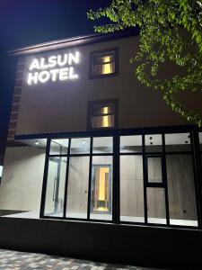 a building with a sign on the side of it at Alsun Hotel in Astana