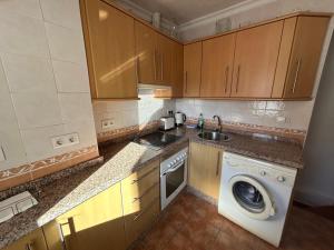 a kitchen with a sink and a washing machine at Casita Maite in Ardales
