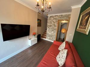 a living room with a red couch and a flat screen tv at Casita Maite in Ardales