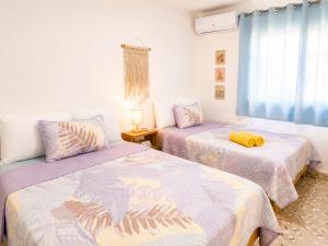 ein Schlafzimmer mit zwei Betten und einem Fenster in der Unterkunft Casa Momo Bacalar in Bacalar
