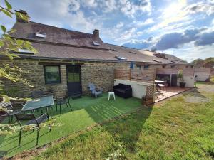 a backyard of a house with a patio and lawn at Studio 11, Draps, Linge, Wifi # Longère Bretonne#Morbihan in Sulniac +4 photos