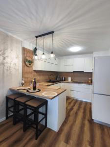 a kitchen with white cabinets and a island with a table at Apartments Šiljug in Cavtat