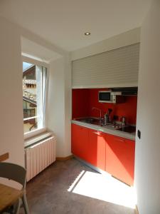 バゴリーノにあるGB Affitti Breviのキッチン(赤いキャビネット、シンク、窓付)