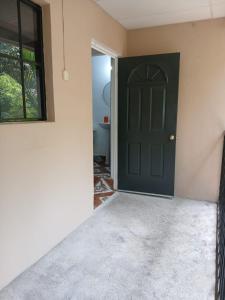 a room with a black door and a window at Tuncosurfhouse in El Sunzal