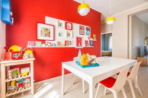 a dining room with a white table and red wall at Henry's House Parma in Parma