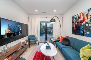 a living room with a blue couch and a table at Hyve-Retro Modern-Full Gym-Walk to Broadway in Nashville