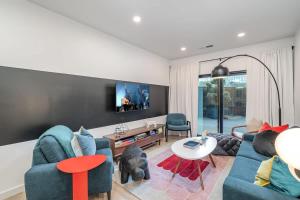 a living room with two blue couches and a tv at Hyve-Retro Modern-Full Gym-Walk to Broadway in Nashville +72 photos