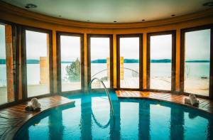 a large swimming pool in a room with windows at El Faro Boutique Hotel & Spa by DON in Villa La Angostura