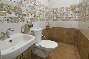 a bathroom with a white toilet and a sink at De Majestic SSK Paradise Beach Villa in Pondicherry +12 photos