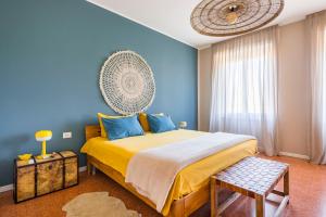 a bedroom with a large bed with blue walls at Henry's House Parma in Parma