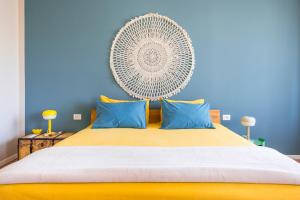 a bedroom with a large yellow bed with blue walls at Henry's House Parma in Parma +16 photos