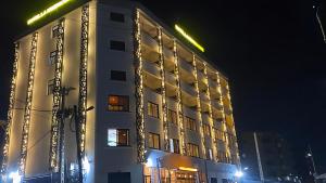 a white building with lights on the side of it at Hôtel La Miséricorde in Douala