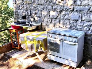 an outdoor kitchen with a stove and a sink at Milly Lake in Claino +27 photos