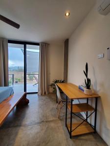 a bedroom with a desk and a table with a view at Pitaya Guest Suite in El Pescadero