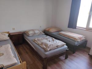 a room with three beds and a window at Hostel Drahonice in Drahonice