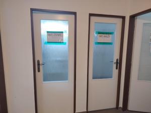 three doors with a sign that reads emergency and wizards at Hostel Drahonice in Drahonice