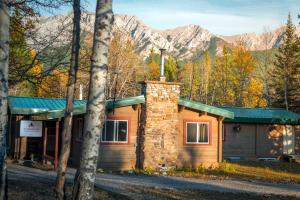 a cabin in the woods with mountains in the background at HI Kananaskis Wilderness - Hostel in Kananaskis Village