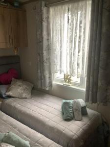 a bedroom with a bed and a window with curtains at Home from Home in Eyemouth