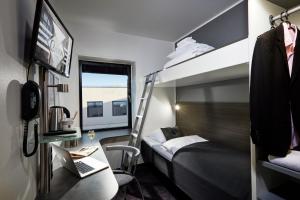 a hotel room with two bunk beds and a desk at Cabinn Aarhus in Aarhus