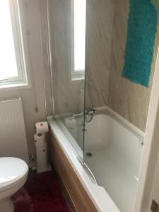 a bathroom with a bath tub and a toilet at Home from Home in Eyemouth +6 photos