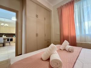 a bedroom with a pink bed with towels on it at Little Spyrela in Sinarádes