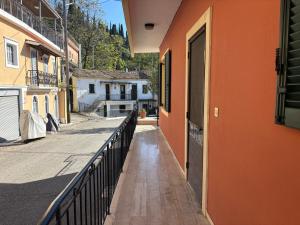 an alley with an orange building and a balcony at Little Spyrela in Sinarádes