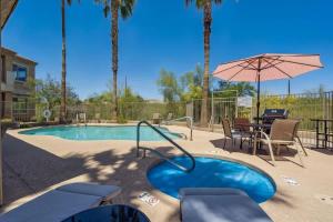 a swimming pool with a table and an umbrella at Panorama View - Mountain Views - Community Pool in Fountain Hills