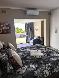 a hotel room with a large bed and a living room at Protea House - self-catering house with a Pool in Durban