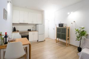 a small kitchen with white cabinets and a table at Silent Paradise Drago Complex in Costa Del Silencio