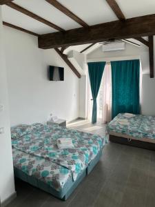 a bedroom with two beds and green curtains at Smestaj Milovanovic in Soko Banja