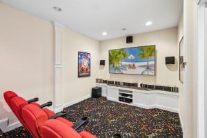 a room with red chairs and a flat screen tv at 6107 - No Wake Zone in Nags Head