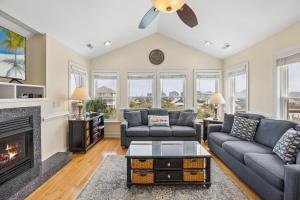 a living room with couches and a fireplace at 6107 - No Wake Zone in Nags Head