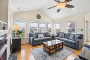 a living room with couches and a fireplace at 6107 - No Wake Zone in Nags Head +76 photos