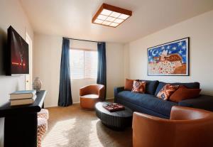 a living room with a blue couch and a chair at Cactus Spur - Pool & Fire Pit - Mins to Old Town in Scottsdale
