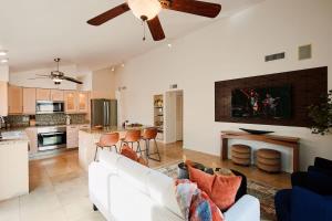 a living room with a white couch and a kitchen at Cactus Spur - Pool & Fire Pit - Mins to Old Town in Scottsdale