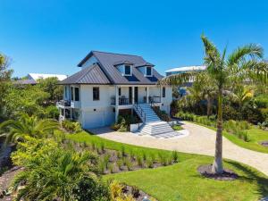 a house with a palm tree in front of it at Pelican's Perch in Sanibel