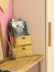 two baskets sitting on a table with books at Vagabondes - Chambres d'hôtes à Azay-Le-Rideau in Azay-le-Rideau