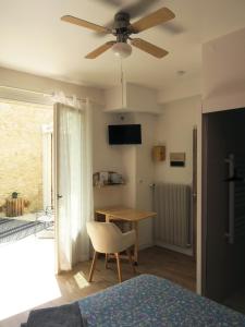 a bedroom with a ceiling fan and a table and a chair at Vagabondes - Chambres d'hôtes à Azay-Le-Rideau in Azay-le-Rideau