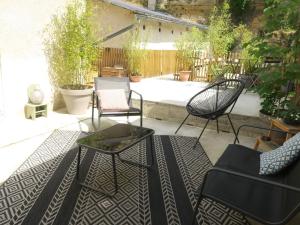 a patio with chairs and a table on a rug at Vagabondes - Chambres d'hôtes à Azay-Le-Rideau in Azay-le-Rideau