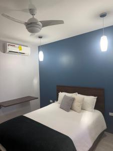 a blue bedroom with a bed with a ceiling fan at Charm New Kingston in Kingston +5 photos
