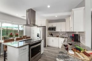 a kitchen with white cabinets and a counter with wine glasses at Pristine Sunset- In Old Town - Private Pool - BBQ in Scottsdale