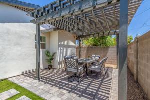 a patio with a table and chairs under a pergola at Pristine Sunset- In Old Town - Private Pool - BBQ in Scottsdale