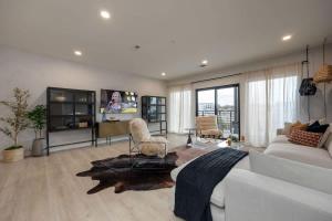 a living room with a white couch and a tv at Hyve - Mahogany - Walk to Broadway in Nashville +105 photos