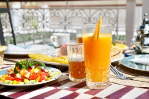 a table with a plate of fruit and a glass of orange juice at Riad Aura Suites & Spa in Marrakesh